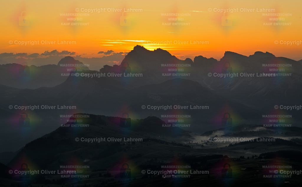 Morgenleuchten in den Dolomiten | Ein Panoramabild vom Sonnenaufgang hinter den Geislerspitzen in den Südtiroler Dolomiten und über der Seiseralm liegt noch der Frühnebel.