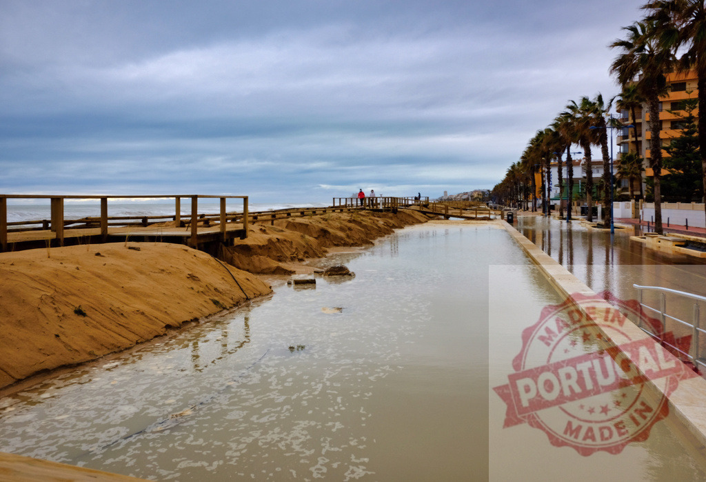 Coastal erosion and urban flooding along beach promenade | City street and beach boardwalk flooded during coastal storm with sand erosion - Realisiert mit Pictrs.com