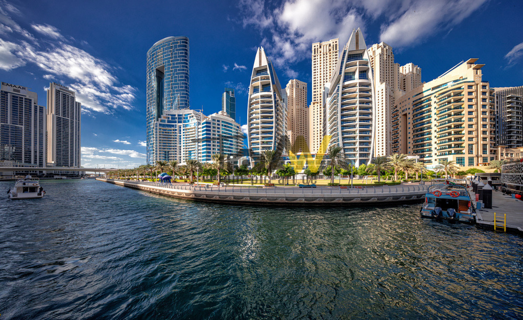 Futuristische Architektur in der Dubai Marina in Dubai---V | Die Abbildung zeigt die Dubai Marina, ein bekanntes Viertel in Dubai, das für seine beeindruckende Skyline und den künstlichen Yachthafen bekannt ist. Das Viertel liegt an einer 3 Kilometer langen künstlichen Wasserstraße und verfügt über eine belebte, 7 Kilometer lange Promenade, den "Marina Walk". Es ist bekannt für seine hohe Dichte an Wolkenkratzern und luxuriösen Wohngebäuden, von denen einige zu den höchsten der Welt gehören. Die Gegend bietet eine Mischung aus urbanem Lebensstil und Strandnähe, mit zahlreichen Restaurants, Bars und Geschäften entlang der Promenade. Die Dubai Marina gilt als eines der stilvollsten und beliebtesten Ziele für Touristen und Einheimische gleichermaßen.  - Realisiert mit Pictrs.com