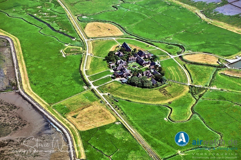 Das Leben auf der kleinen Hallig, die nur 15 Häuser und 23 Einwohner zählt, ist stark von den Gezeiten geprägt - Luftbild | Das Leben auf der kleinen Hallig, die nur 15 Häuser und 23 Einwohner zählt, ist stark von den Gezeiten geprägt: Der Fußballplatz dient als zentrales Element der Gemeinschaft, das bei Hochwasser komplett unter Wasser steht. - Die Bewohner müssen die Tore und Zäune nach dem Rückgang des Wassers wieder freilegen. - Im Gegensatz zu den großen isländischen Fußballligen (wie der Besta deild), die in den Suchergebnissen ebenfalls erwähnt werden, gibt es auf Oland keinen Hinweis auf eine professionelle Liga oder einen Rekordmeister.