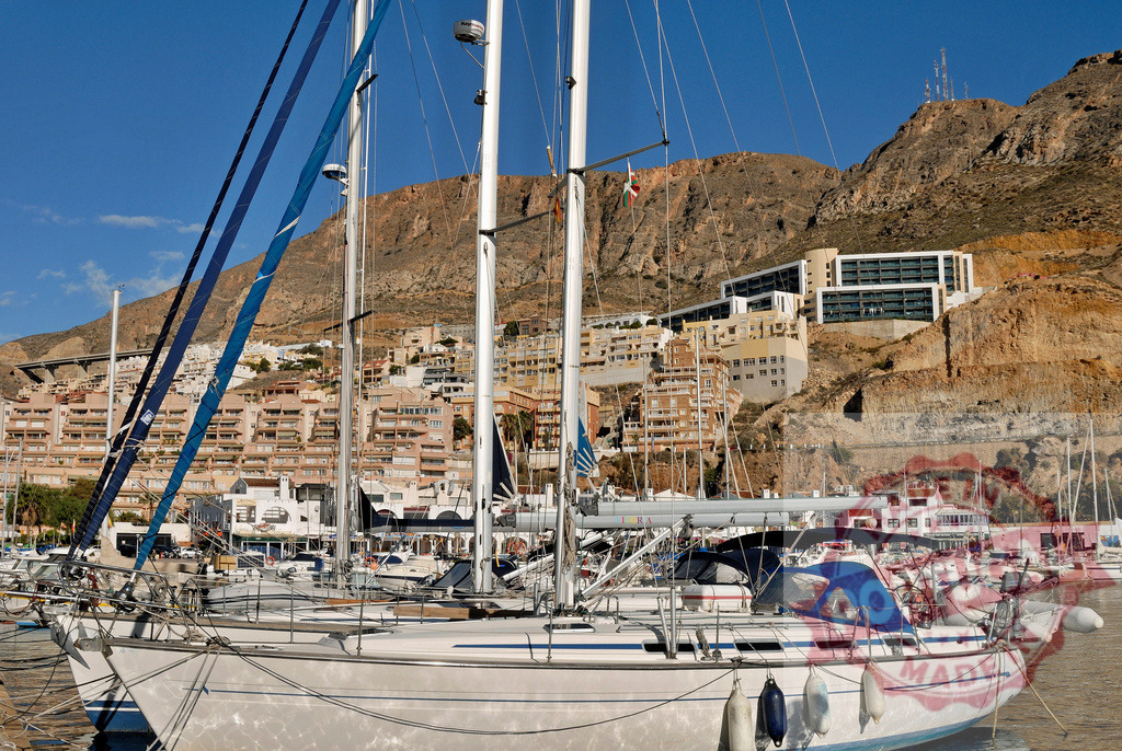Sailboats moored in marina at Costa Blanca | Sailboats floating in a marina with hillside town and mountains in background - Realized with Pictrs.com