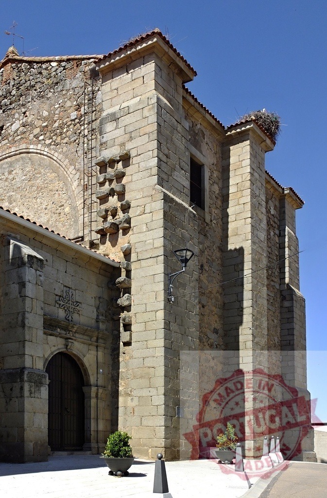 Ancient stone church facade with stork nest on roof. Spain - Extremadura | Old stone church with wooden door and a large stork nest on its historical building - Realisiert mit Pictrs.com