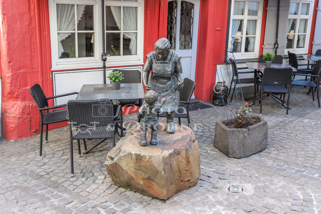 Schnuggel Elsje Boppard-6979 | Statue Frau mit Kind, eine Frau gibt einem Kind Süßigkeiten in die Hand. Statue gesehen in Boppard am Rhein. Es handelt sich um das Schnuggel-Elsje, eine ehemalige Bewohnerin von Boppard am Rhein. - Realisiert mit Pictrs.com