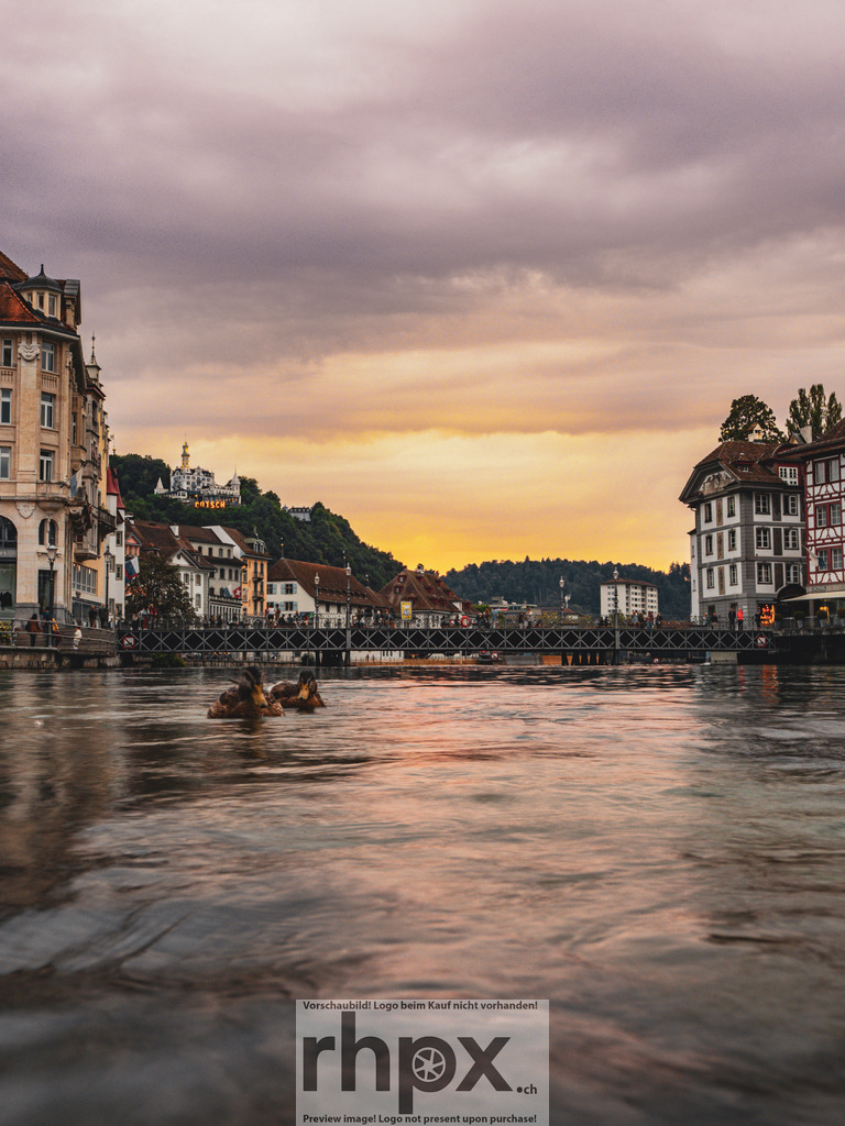 Abendstimmung an der Reuss | <p><strong>Fluss. Abendrot. Ruhe.</strong></p>
<p>Die Reuss fliesst ruhig an den prachtvollen Fassaden der Luzerner Altstadt vorbei. Im sanften Abendlicht thront das Château Gütsch im Hintergrund über dem Wasser und schafft eine Atmosphäre von zeitloser Beständigkeit.</p>
<p>Wähle unter "Produktauswahl" dein Wunschformat: Vom klassischen Wandbild über Puzzle & Tassen bis zum digitalen Download (z.B. als Handy-Hintergrund).</p>
<br>
 - Realisiert mit Pictrs.com