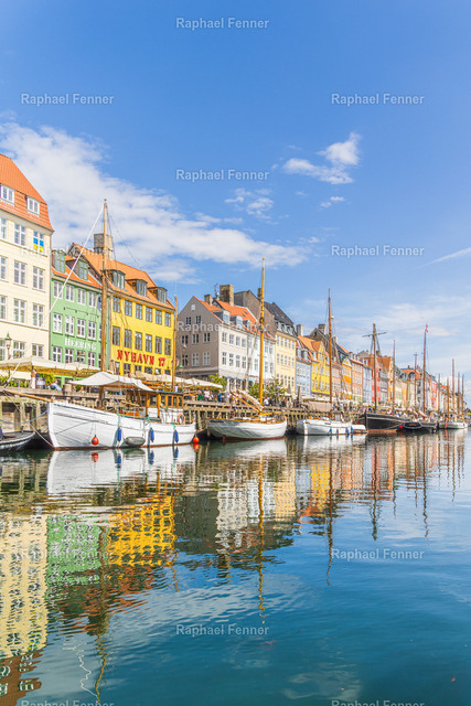 Nyhavn mit Spiegelung | Kopenhagen, Dänemark | Der berühmte Nyhavn in Kopenhagen zählt zu den bekanntesten Sehenswürdigkeiten Dänemarks. Die historischen, farbenfrohen Häuser, traditionellen Segelschiffe und die nahezu perfekte Spiegelung im ruhigen Wasser verleihen diesem Motiv eine besondere Eleganz. Das Bild fängt die maritime Atmosphäre der dänischen Hauptstadt an einem sonnigen Tag ein und verbindet Architektur, Geschichte und nordisches Lebensgefühl.Als hochwertiger Fine-Art-Druck eignet sich dieses Motiv ideal für Wohnräume, Büros oder alle, die die Schönheit Kopenhagens und Skandinaviens schätzen.