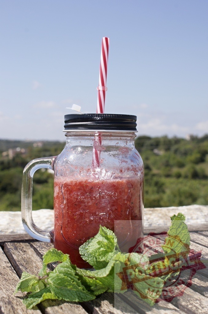 Berry smoothie in mason jar with straw outdoors | Refreshing berry smoothie with mint leaves on a wooden table, enjoying summer nature - Realisiert mit Pictrs.com