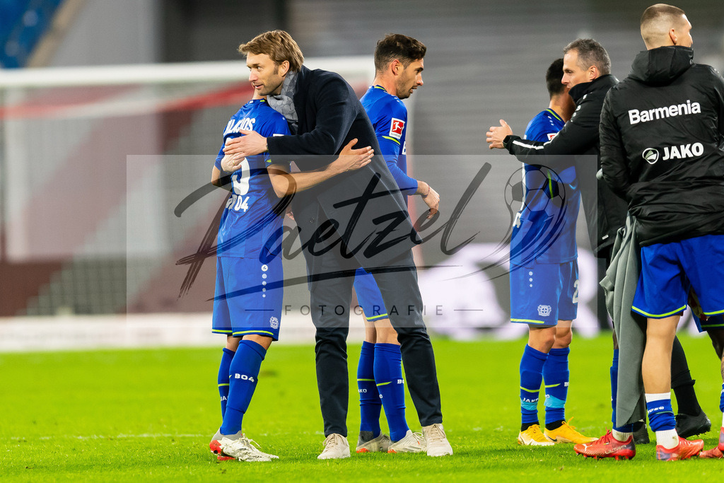 RBLLEV20211128_089 | Fussball, Herren: Exequiel Palacios (Bayer 04 Leverkusen) und Sportdirektor Simon Rolfes (Bayer 04 Leverkusen) geben sich die Hand bei dem Spiel der 1. Bundesliga zwischen RB Leipzig und Bayer 04 Leverkusen in der Red Bull Arena am 28.11.2021 in Leipzig, Deutschland.DFB / DFL REGULATIONS PROHIBIT ANY USE OF PHOTOGRAPHS AS IMAGE SEQUENCES AND/OR QUASI-VIDEO. - Realisiert mit Pictrs.com
