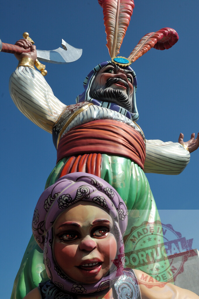 Fallas ninot sculpture depicting a Moorish character in Valencia Spain. Fallas Fiestas Communidad Valenciana | Exaggerated caricature sculpture, a Fallas ninot, reaching towards a bright blue sky - Realized with Pictrs.com