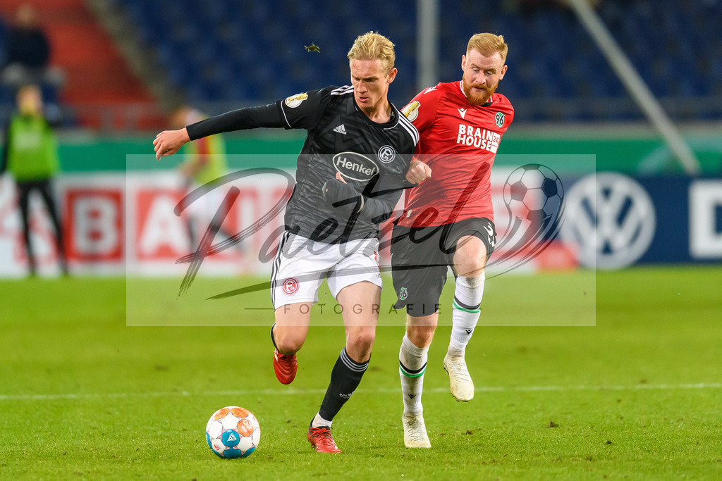 H96DUS20211027_047 | Fussball, Herren: Christoph Klarer (Fortuna Duesseldorf) und Sebastian Kerk (Hannover 96) im Zweikampf bei dem Spiel der 2. Runde im DFB-Pokal zwischen Hannover 96 und Fortuna Duesseldorf in der HDI-Arena am 27.10.2021 in Hannover, Deutschland.DFB / DFL REGULATIONS PROHIBIT ANY USE OF PHOTOGRAPHS AS IMAGE SEQUENCES AND/OR QUASI-VIDEO. - Realisiert mit Pictrs.com