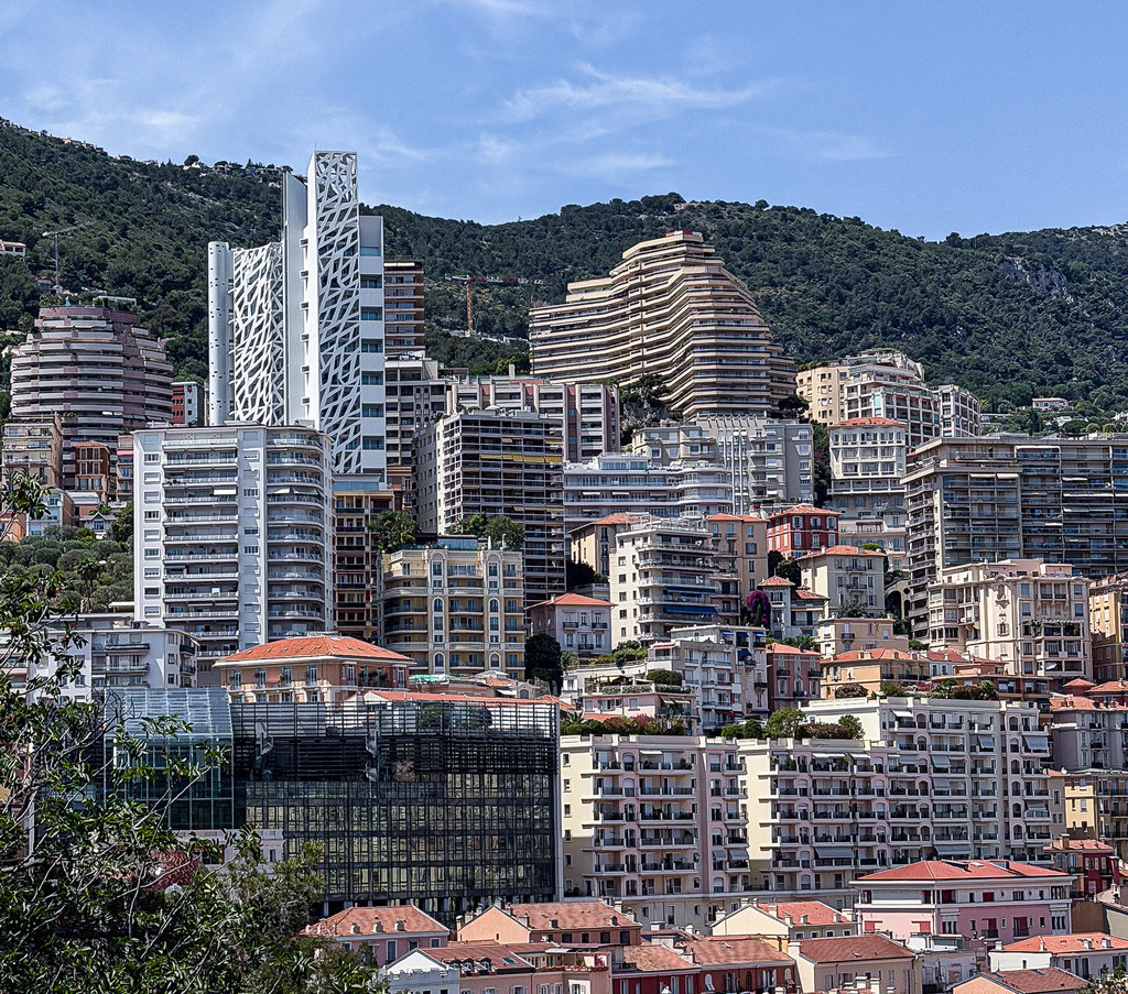 Wandbild Kunstdruck Poster Moderne Skyline – Urbanes Stadtpanorama am Meer | Bringen Sie die beeindruckende Dynamik und die architektonische Vielfalt einer modernen Metropole direkt an Ihre Wand. Dieses exklusive Wandbild zeigt ein faszinierendes Stadtpanorama mit einer dichten, majestätischen Skyline über dem glitzernden Meer. Die geometrische Anordnung der Gebäude und das weite, mediterrane Licht machen dieses Motiv zu einem absoluten Design-Statement. Gedruckt auf Premium-Leinwand, feinstem Alu-Dibond oder kristallklarem Acrylglas garantiert dieses Kunstwerk ein edles Galerie-Gefühl in Ihrem Wohnzimmer, Büro oder Loft. - Realisiert mit Pictrs.com