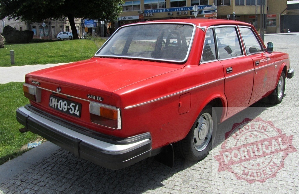 Red Volvo 244 DL vintage car parked on cobblestone | Red Volvo 244 DL vintage sedan parked on historic cobblestone in an urban setting - Realized with Pictrs.com