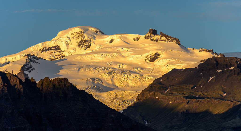 island-2020-402 | Der Hvannadalshnúkur ist mit 2.110 m der höchste Gipfel Islands. Er befindet sich im Skaftafell-Nationalpark und gehört zum Gletscher Öræfajökull, der Teil des Vatnajökull ist. Die Fotografie entstand im späten Abendlicht. - Realisiert mit Pictrs.com
