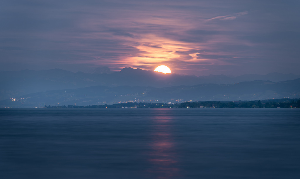 Mondaufgang über den Alpen am Bodensee | Der Mond geht hinter den Bergen der Alpen auf und sein Licht spiegelt sich im Bodensee. - Realized with Pictrs.com