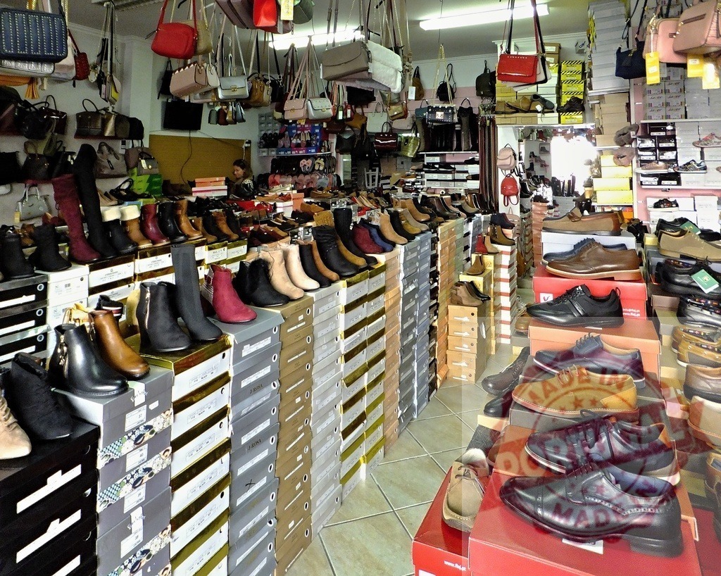 Retail store selling many shoes, boots, and handbags | Interior of a retail shop displaying various shoes, boots, and handbags for sale - Realisiert mit Pictrs.com