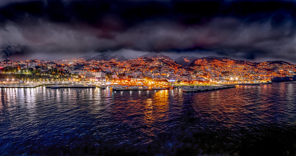 Glitzerndes beleuchtetes Funchal auf Madeira bei Nacht-Azoren | Das Bild zeigt die Küstenstadt Funchal auf der portugiesischen Insel Madeira bei Nacht.Ort: Funchal, die Hauptstadt von Madeira, an der Südküste der Insel.Ansicht: Blick auf die beleuchtete Bucht und den Hafen mit den Lichtern der Stadt und den Bergen im Hintergrund bei Nacht - Realisiert mit Pictrs.com