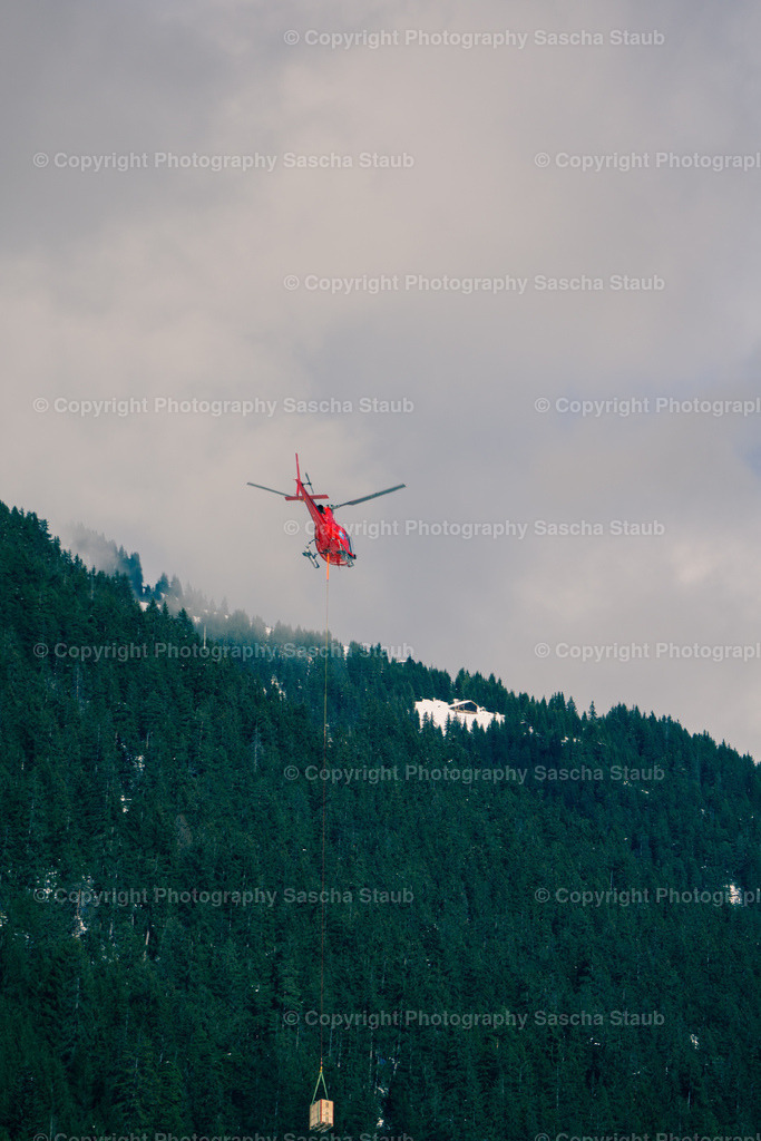 Hubschrauber mit Last beim Wegflug - hochkant | Willkommen im Shop von Photography Sascha Staub. Hier findest du alle Fotos und Medieninhalten von Sascha Staub. In diesem Shop kannst du Lizenzen zu den Fotos, Drucke und Gutscheine für den Shop erwerben.  - Realisiert mit Pictrs.com