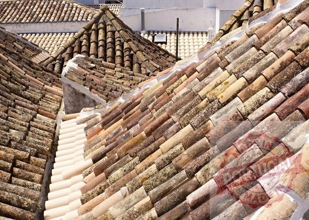 Old mediterranean terracotta roof tiles covering traditional houses creating a geometric pattern | Many old, weathered terracotta roof tiles covering traditional houses creating a geometric pattern - Realisiert mit Pictrs.com