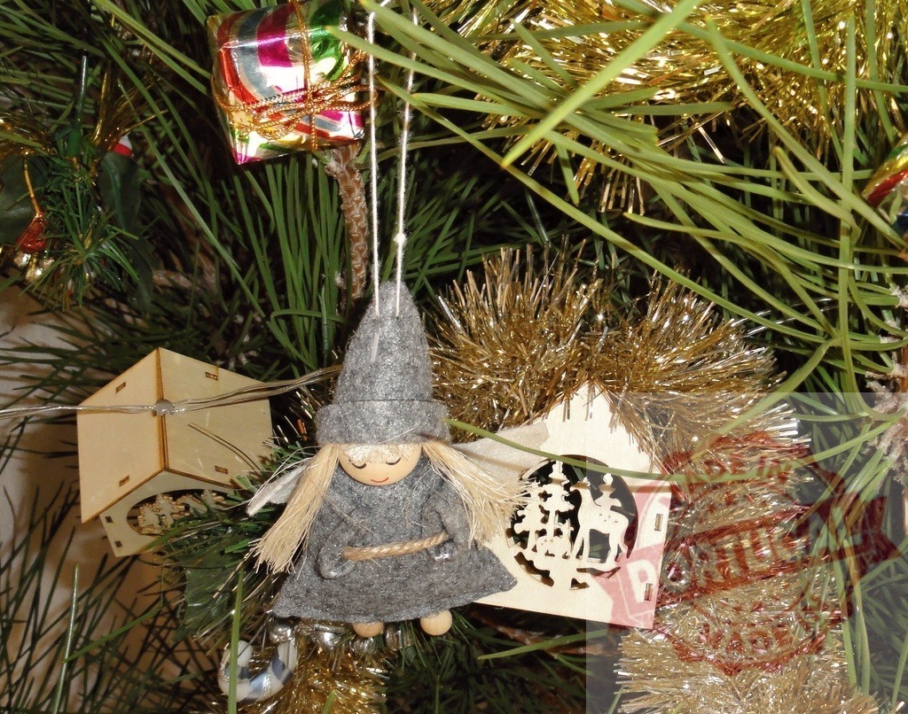 Christmas tree decorated with handmade angel, wooden house and gift | Christmas tree is decorated with handmade angel, wooden house and gift, representing holiday spirit and traditions - Realisiert mit Pictrs.com