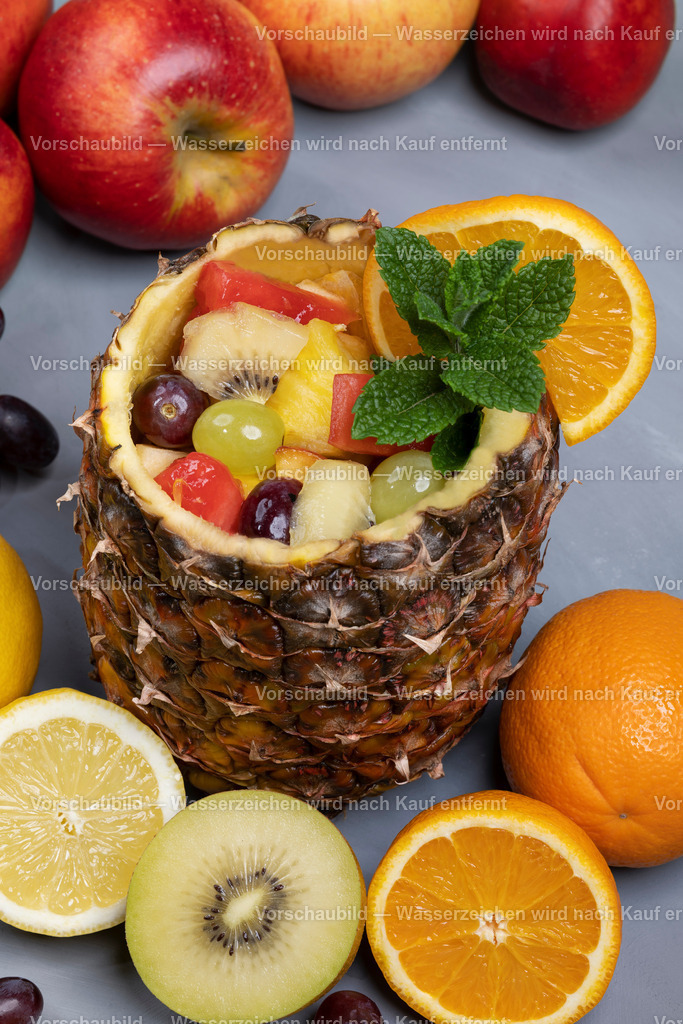 frischer Obstsalat in ausgehöhlter Ananas serviert | frischer Obstsalat in ausgehöhlter Ananas serviert, dekoriert mit Obst und Minze - Realisiert mit Pictrs.com