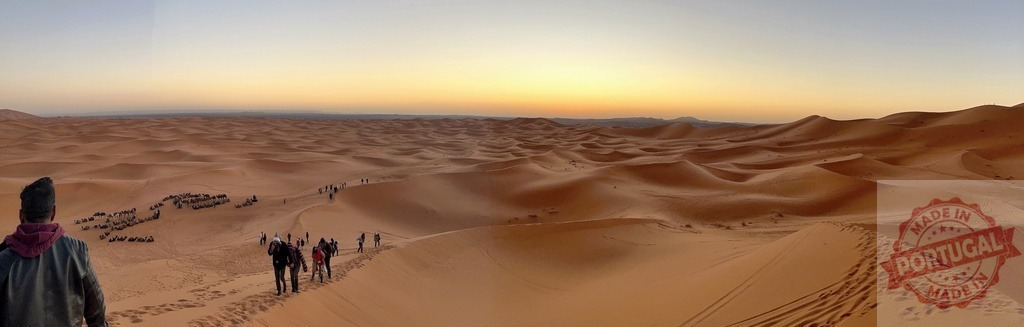 Tourists walking on sand dunes in Sahara Desert at sunset | Tourists walking on sand dunes in Sahara Desert at sunset, enjoying breathtaking view - Realized with Pictrs.com
