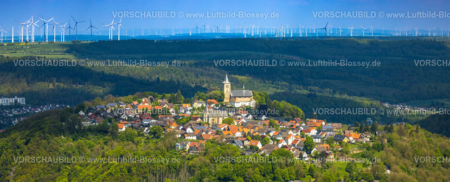 Marsberg240504131Obermasberg-2 | Luftbild, Wohngebiet Ortsansicht Obermarsberg auf einem bewaldeten Berg, vorne römisch-katholische St. Nikolaikirche, hinten Stiftskirche St. Peter und Paul und Hein-Stiftung, im Hintergrund riesiger Windpark und Windräder, Obermarsberg, Marsberg, Sauerland, Nordrhein-Westfalen, Deutschland