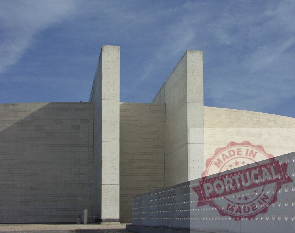 Modern Church of Fátima Sanctuary imposing concrete walls rising towards a blue sky | Church of Fátima Sanctuary concrete walls rising towards a blue sky, casting shadows on the textured facade - Realisiert mit Pictrs.com