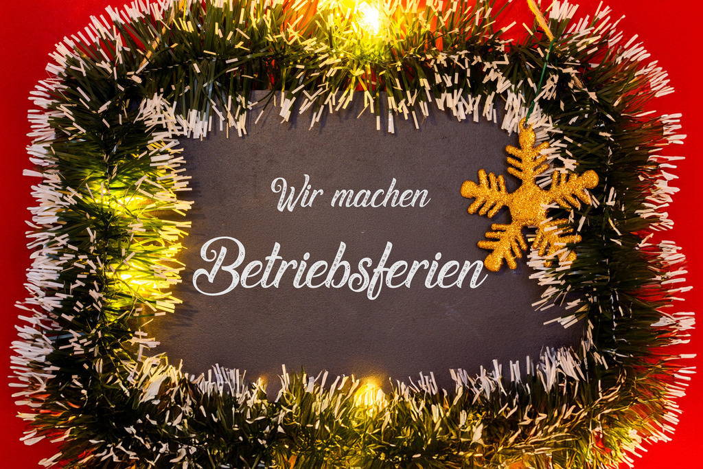 WIR MACHEN BETRIEBSFERIEN (Weihnachten) | Schild mit dem Schriftzug WIR MACHEN BETRIEBSFERIEN mit weihnachtlicher Dekoration - Realisiert mit Pictrs.com
