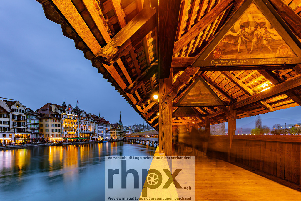 Kapellbrücke Luzern bei Abendstimmung | Holz. Fluss. Dämmerung.Die historischen Balken der Brücke bilden einen natürlichen Rahmen für den Blick auf die Stadt. Das sanfte Farbspiel des Abendhimmels und die ruhige Spiegelung in der Reuss tauchen die Stadt in eine magische Atmosphäre.Wähle unter "Produktauswahl" dein Wunschformat: Vom klassischen Wandbild über Puzzle &amp; Tassen bis zum digitalen Download (z.B. als Handy-Hintergrund). - Realisiert mit Pictrs.com