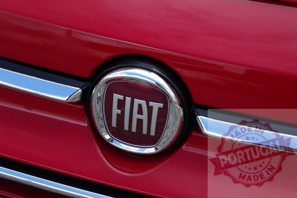 Fiat emblem on red car with chrome detail | Fiat logo on the front grill of a red automobile - Realized with Pictrs.com