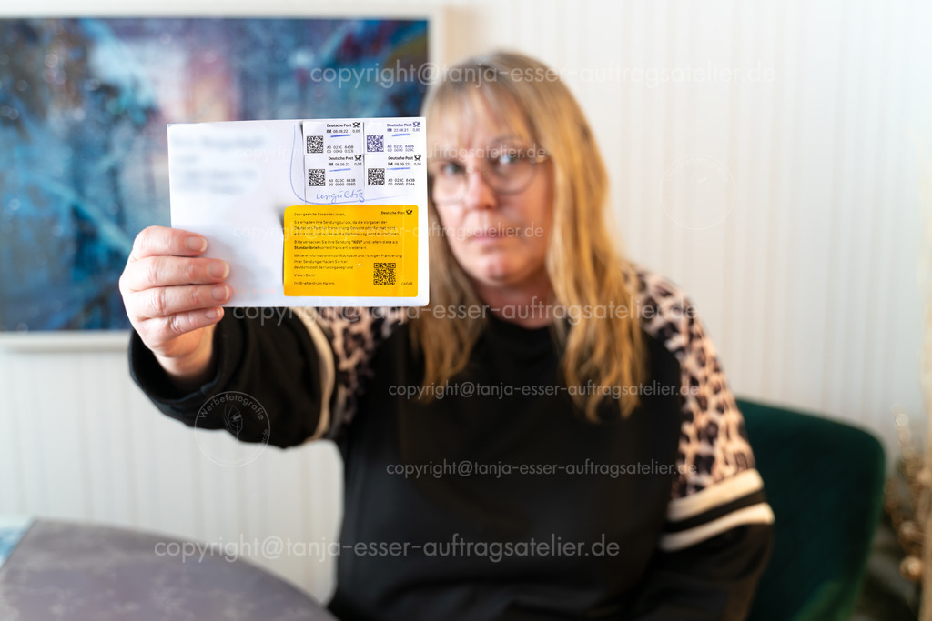 Frau hält Brief mit Online Marke hoch der zurück gegeben wurde ist | Brilon, Deutschland 29. Januar, 2026: Unzufriedene Frau zeigt zurückgewiesenen Brief mit ungültiger Internetmarke der Deutschen Post. Auf dem Brief klebt ein gelber Hinweis der Deutschen Post, der darauf hinweist, dass die Sendung nicht den Frankiervorgaben entspricht. Die verwendeten Internetmarken wurden mit dem handschriftlichen Vermerk „ungültig“ markiert. Das Bild illustriert Probleme mit der Gültigkeitsdauer von Online-Porto, Post-Rückläufer und den Ärger über bürokratische Hürden im Versandwesen.                       