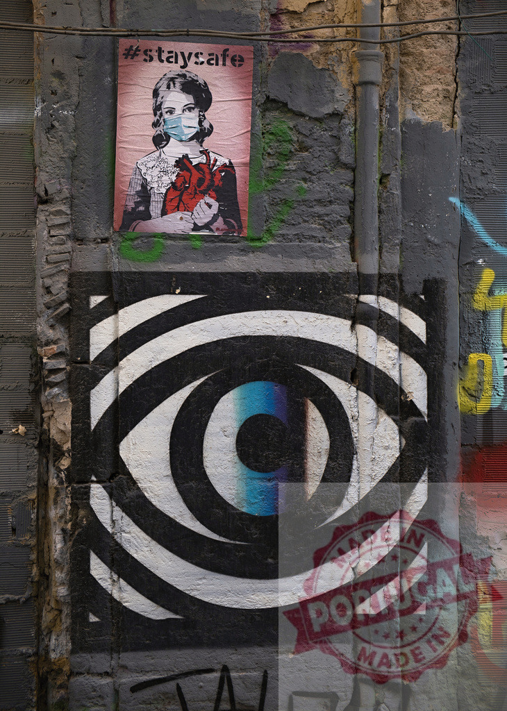 Street art mural showing stay safe message and eye | Urban street art displaying a girl in a medical mask holding a heart and an abstract eye symbol - Realized with Pictrs.com