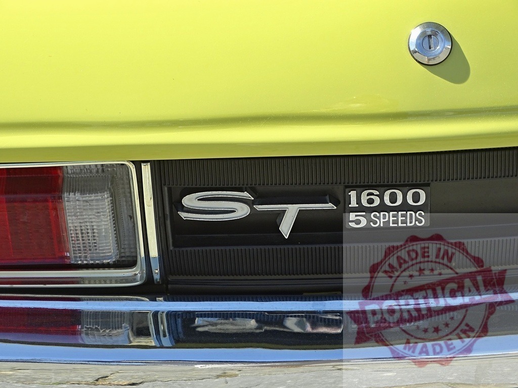 Vintage lime yellow car rear close-up details | Emblems and taillight on rear of a classic car, showing design and chrome - Realized with Pictrs.com