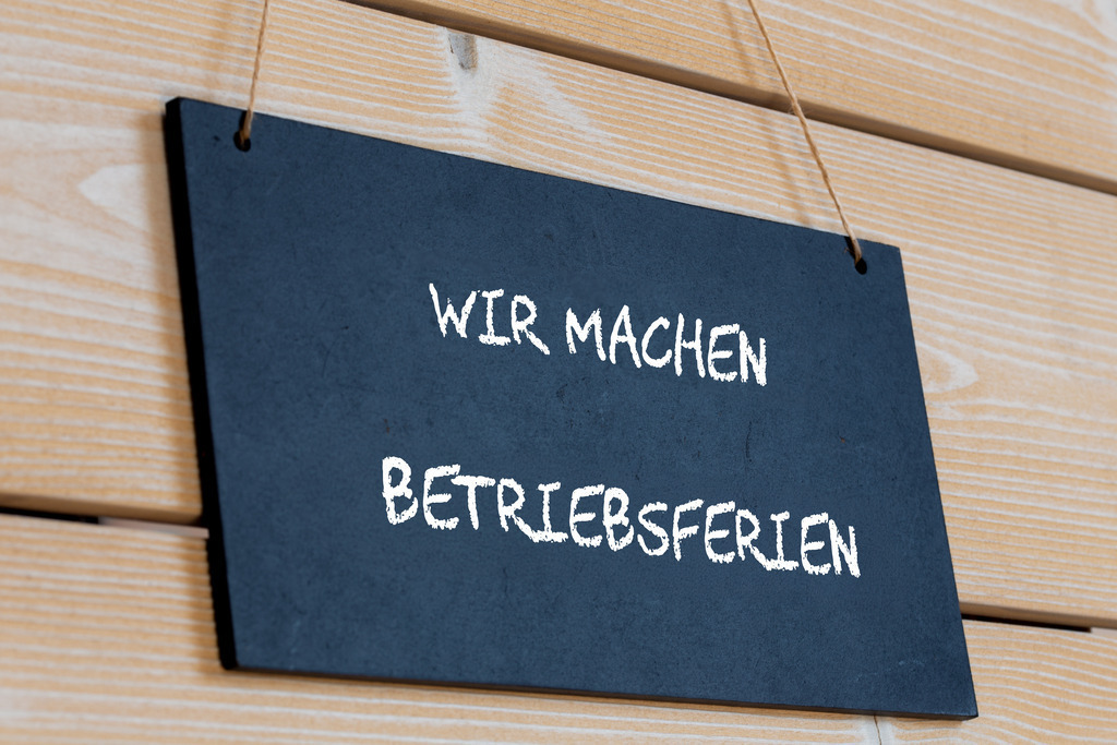 Symbolbild Betriebsferien: Schild an einer Holztafel mit der Aufschrift WIR MACHEN BETRIEBSFERIEN | Symbolbild Betriebsferien: Schild an einer Holztafel mit der Aufschrift WIR MACHEN BETRIEBSFERIEN - Realisiert mit Pictrs.com
