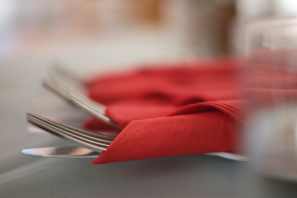 in roter Serviette eingepacktes Essbesteck auf dem Tisch | Retz, Austria - January 28, 2024: in roter Serviette eingepacktes Essbesteck auf dem Tisch liegend. - Realisiert mit Pictrs.com