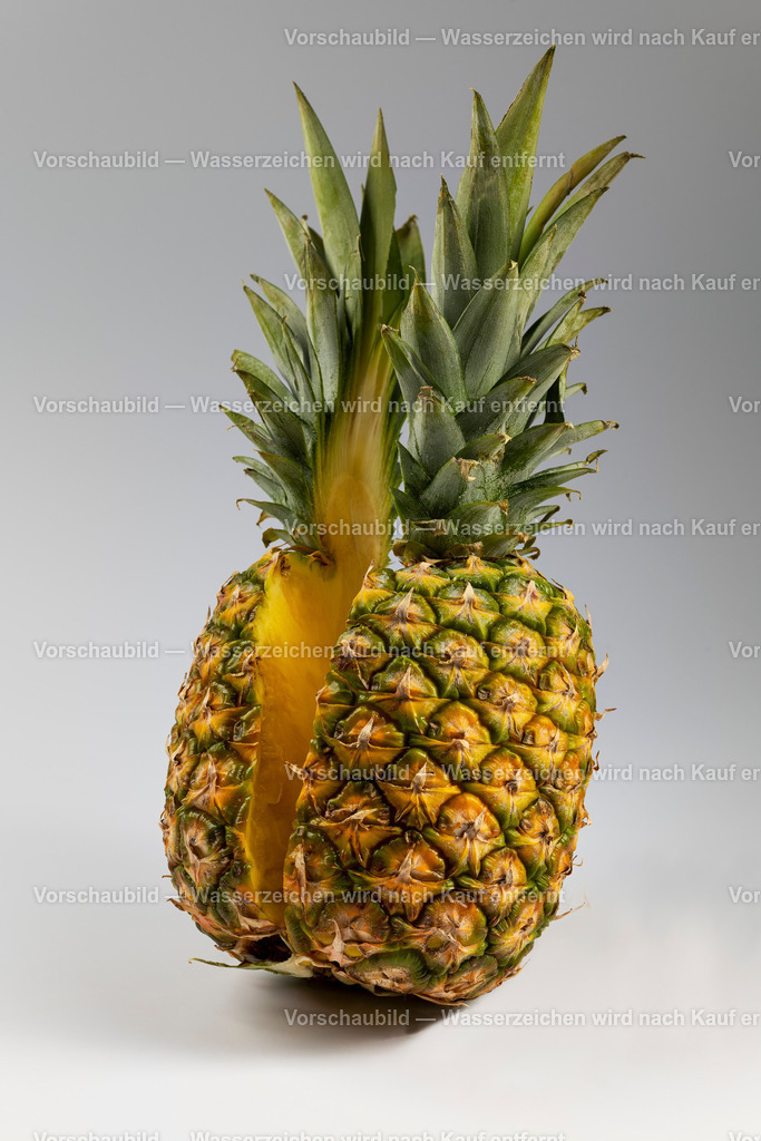Eine ganze Ananas, in derr mitte halbier mit Blick auf das saftige Fruchtfleisch | Eine ganze Ananas, in derr mitte halbier mit Blick auf das saftige Fruchtfleisch - Realisiert mit Pictrs.com