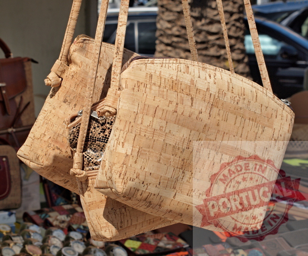 Cork handbags hanging at outdoor street market stall | Cork handbags displaying sustainable fashion and natural texture at an artisan market - Realisiert mit Pictrs.com