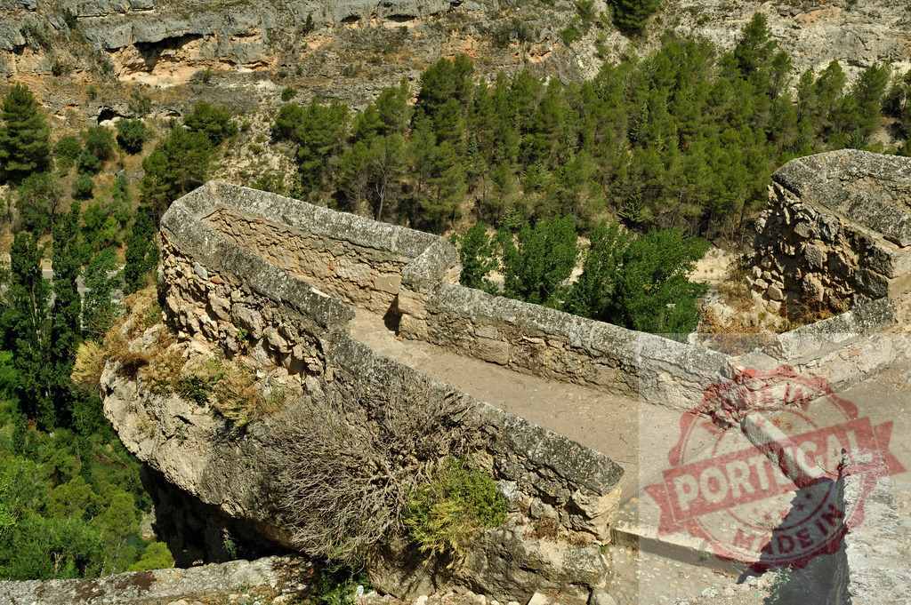 Alarcón stone bridge crossing a deep ravine. Cuenca - Spain | Historic stone bridge and path overlooking a deep gorge and lush forest near Alarcón, Spain - Realized with Pictrs.com
