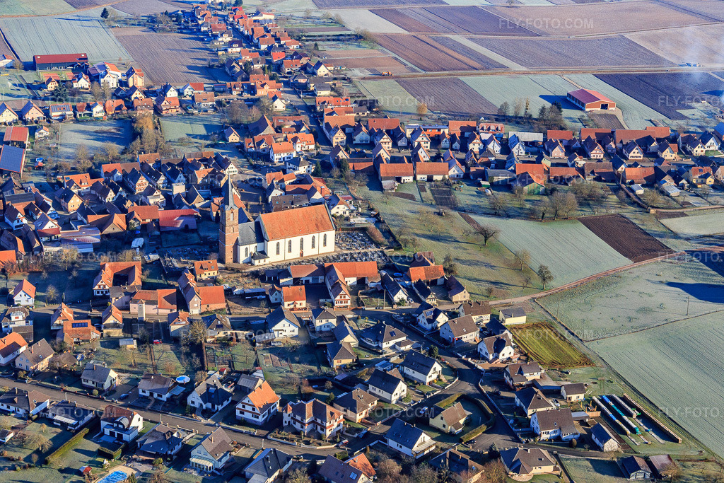 Aerial view: Dormitte with Église Saint-Barthélemy de Schleithal from the southeast in Schleithal in the state Bas-Rhin, France. – Photo: IMG_124076.jpg taken on 01/11/2021 by Werner Riehm/FLY-FOTO.com – Resolution of the original: 5472 x 3648 px