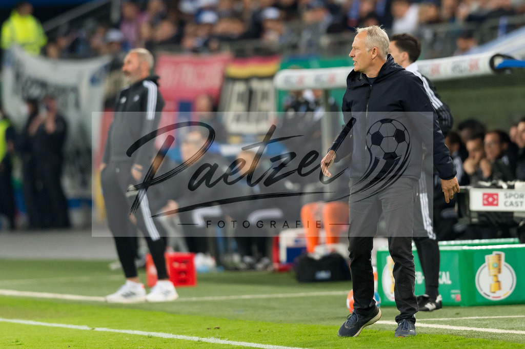 HSVSCF20220419_094 | Fussball, Herren: Trainer Christian Streich (SC Freiburg) schaut beim DFB-Pokal-Halbfinalspiel zwischen Hamburger SV und SC Freiburg im Volksparkstadion am 19.04.2022 in Hamburg, Deutschland.DFB / DFL REGULATIONS PROHIBIT ANY USE OF PHOTOGRAPHS AS IMAGE SEQUENCES AND/OR QUASI-VIDEO. - Realisiert mit Pictrs.com