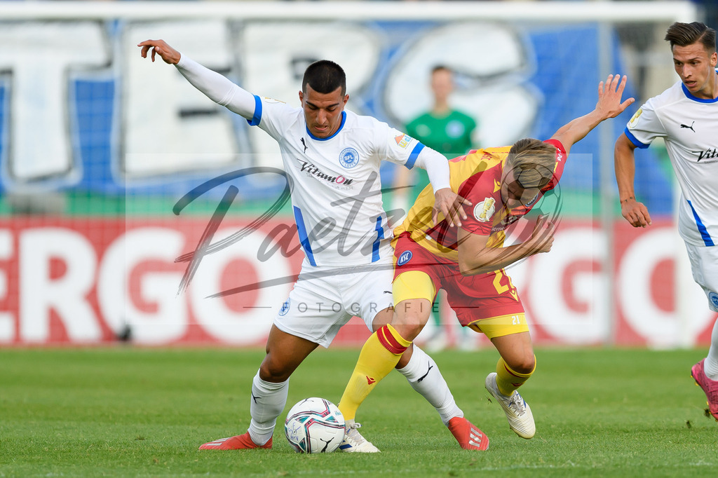 LOTKSC20210809_019 | Fussball, Herren: Muhammed Terzi (Sportfreunde Lotte) und Christoph Kobald (Karlsruher SC) im Zweikampf beim Spiel der 1. Runde im DFB-Pokal zwischen SF Lotte und Karlsruher SC im Stadion am Lotter Kreuz am 09.08.2021 in Lotte, Deutschland.DFB / DFL REGULATIONS PROHIBIT ANY USE OF PHOTOGRAPHS AS IMAGE SEQUENCES AND/OR QUASI-VIDEO. - Realisiert mit Pictrs.com