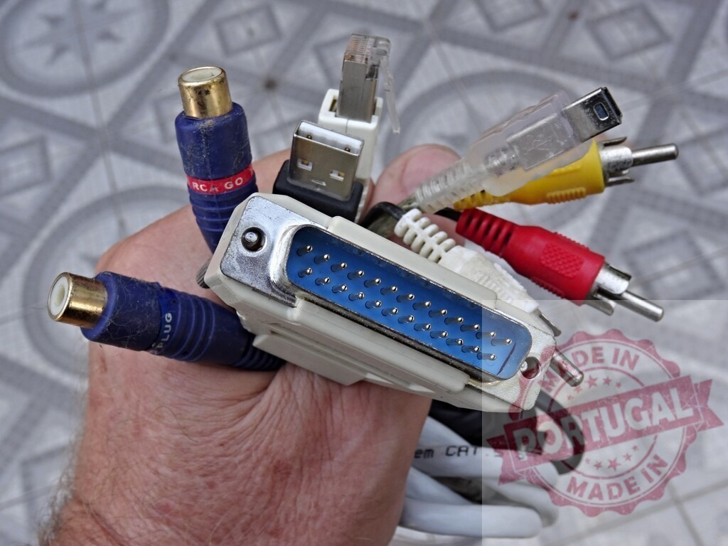 Technician holding different types of connectors and cables | Hand holding various connectors and cables for audio, video, and data transmission - Realized with Pictrs.com