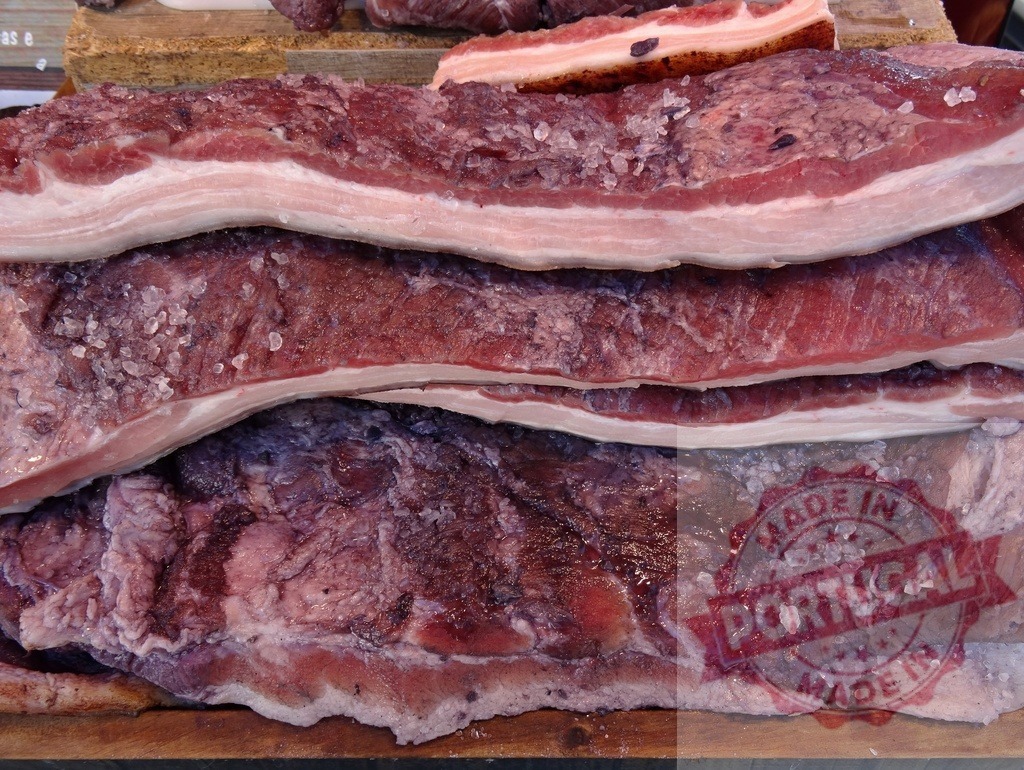 Curing pork belly with coarse salt for bacon | Raw pork belly slabs covered with large salt crystals for traditional curing process - Realized with Pictrs.com