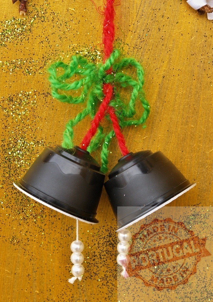 Christmas bells made from recycled coffee capsules hanging on golden background | Two christmas bells made from recycled coffee capsules hanging on golden background with green glitter - Realized with Pictrs.com