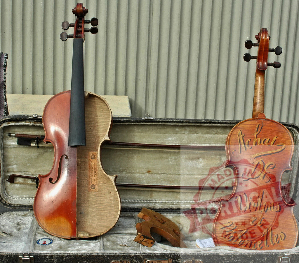 Two violins resting on open violin case showing contrasting conditions | One violin is open showing its interior while the other is fully assembled and bears a french inscription - Realized with Pictrs.com