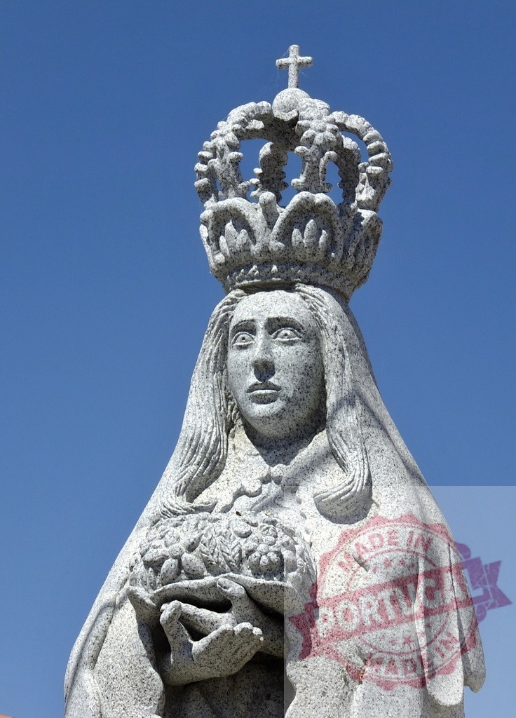 Saint Elizabeth of Portugal queen statue holding roses miracle. Spain - Extremadura | Granite sculpture of Saint Elizabeth of Portugal with crown and roses against blue sky - Realized with Pictrs.com