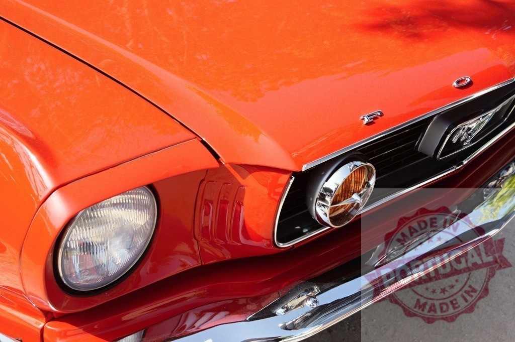 Red Ford Mustang vintage muscle car front detail | Red Ford Mustang front showing headlight, grille, and chrome bumper - Realized with Pictrs.com