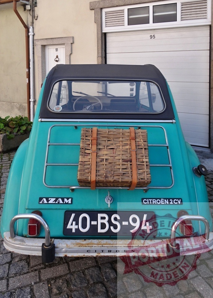 Citroën 2CV car carrying picnic basket through Portugal street | Teal vintage Citroën 2CV car with picnic basket on luggage rack, parked on cobblestone street - Realisiert mit Pictrs.com