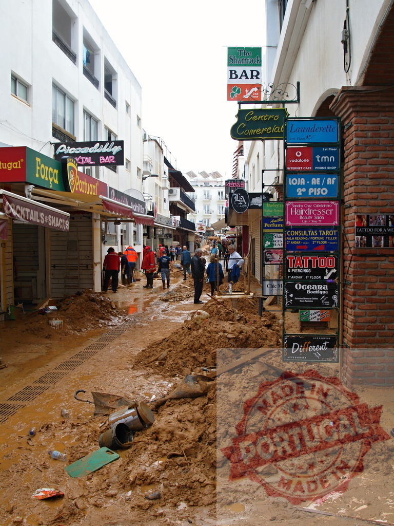 Albufeira street after a devastating mud flood disaster | Albufeira Flood - discruction by weather problems Street covered in thick mud and debris, showing the aftermath of a natural disaster - Realized with Pictrs.com