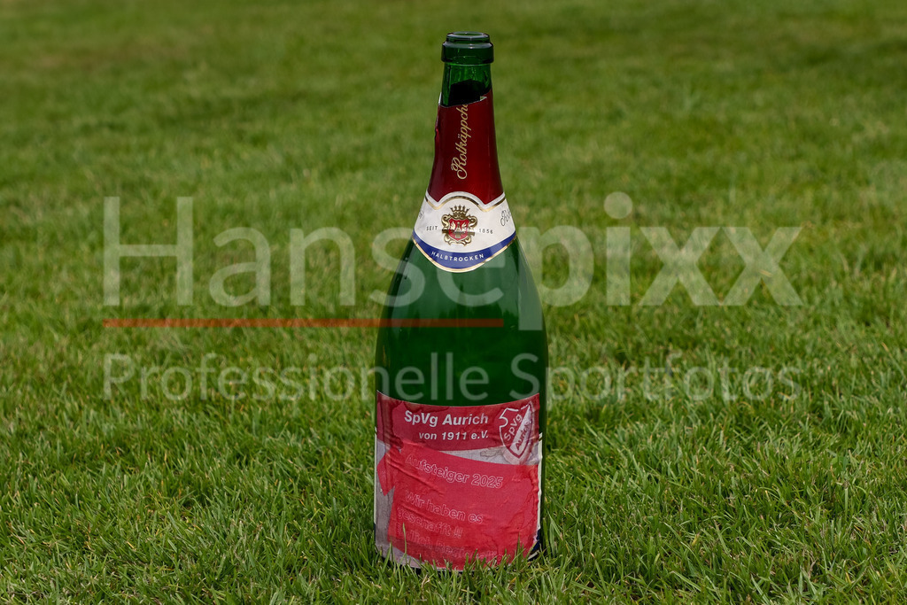 Fussball, Aufstiegsspiel Regionalliga Nord Frauen, SpVg Aurich - SSC Hagen Ahrensburg | Eine Sektflasche steht auf dem Spielfeld, Rasen mit einem speziellen Etikett mit der Aufschrift SpVg Aurich, Aufsteiger 2025, Wir haben es geschafft, Endlich Regionalliga
