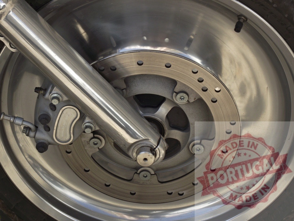 Harley-Davidson motorcycle front wheel and disc brake | Chrome fork and shiny metallic disc brake assembly on a classic motorcycle wheel - Realisiert mit Pictrs.com